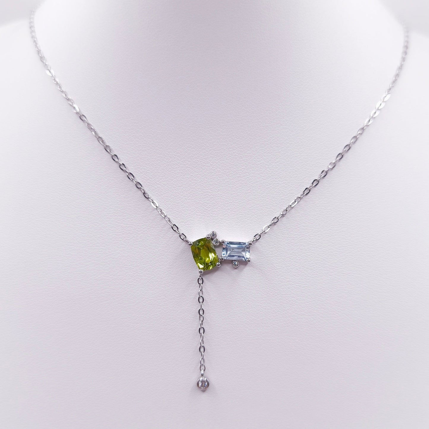 Sterling silver toi et moi necklace with oval peridot and emerald-cut Swiss blue topaz gemstones, 7x5 mm