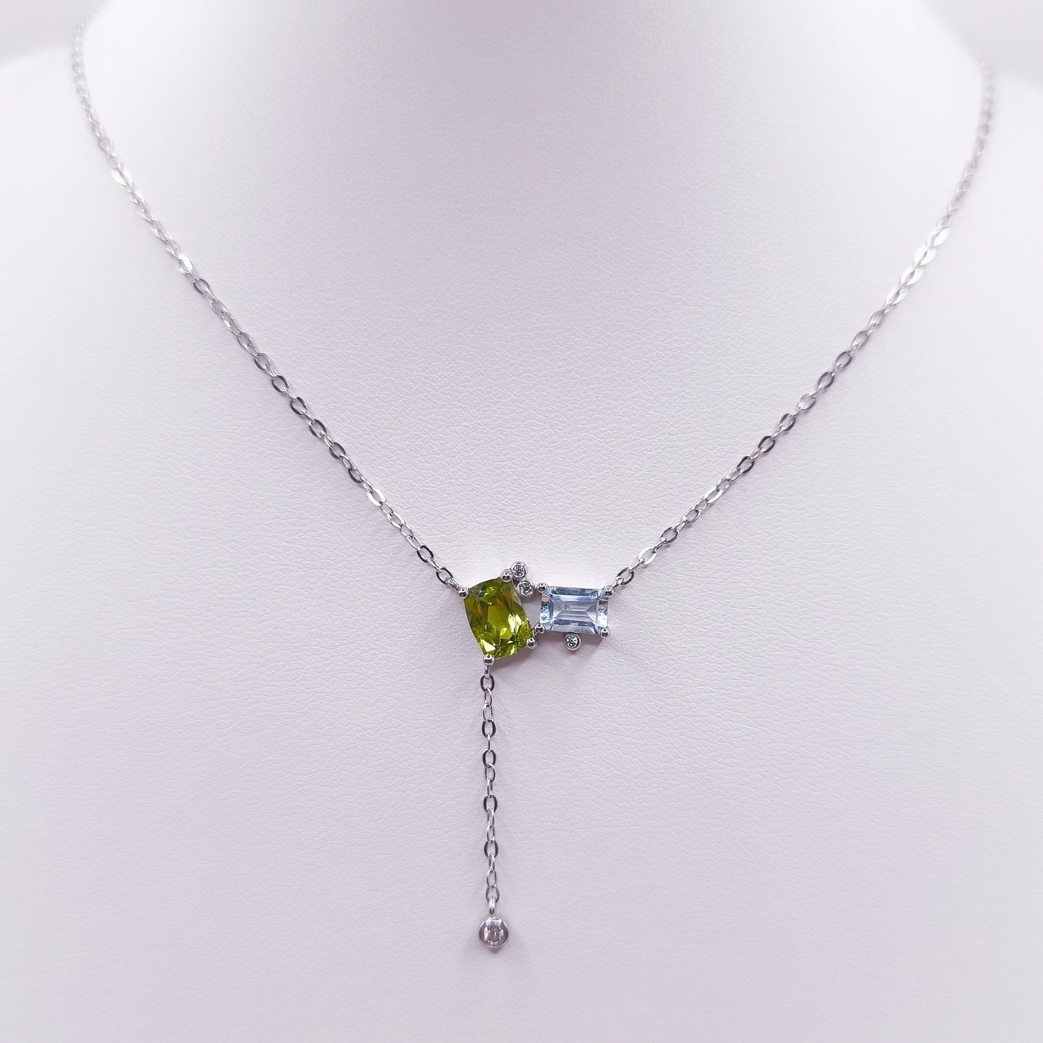 Sterling silver toi et moi necklace with oval peridot and emerald-cut Swiss blue topaz gemstones, 7x5 mm