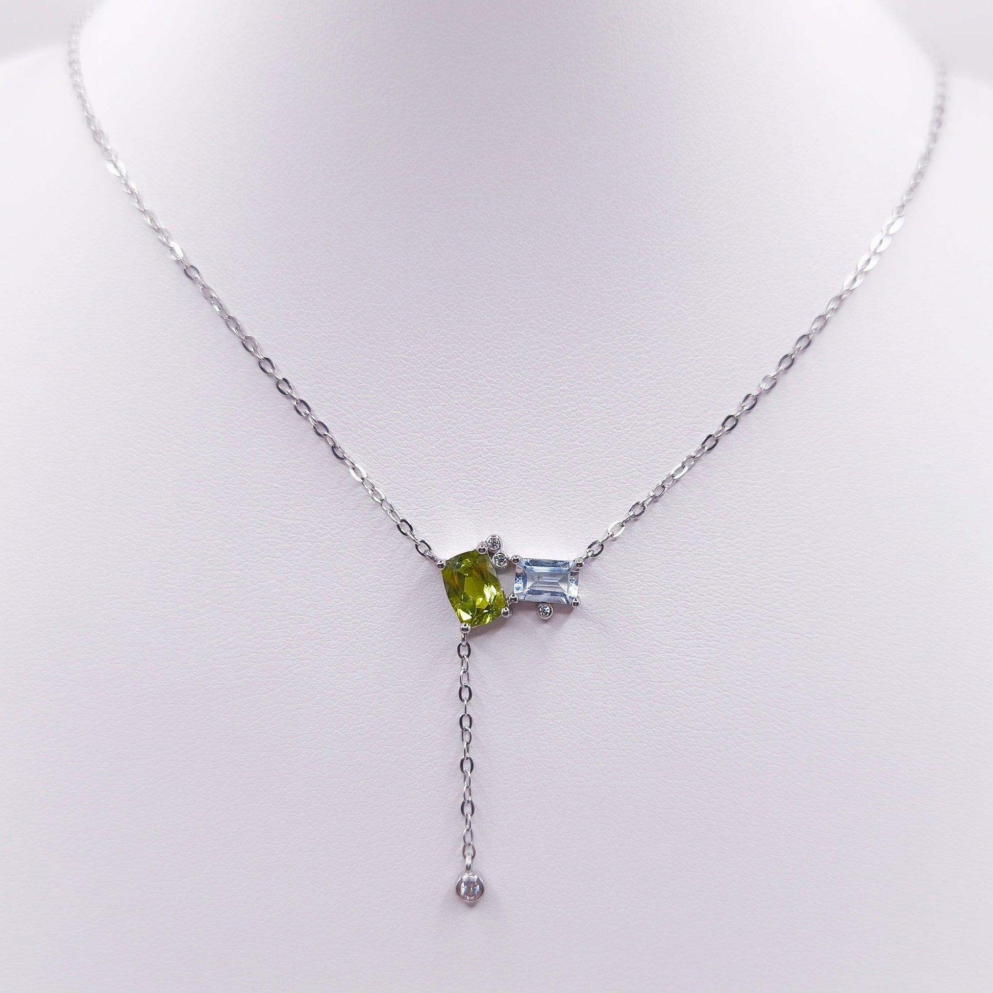 Sterling silver toi et moi necklace with oval peridot and emerald-cut Swiss blue topaz gemstones, 7x5 mm