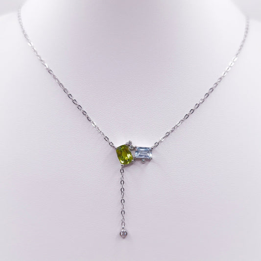 Sterling silver toi et moi necklace with oval peridot and emerald-cut Swiss blue topaz gemstones, 7x5 mm