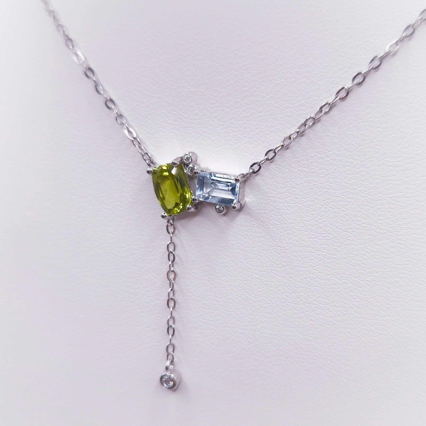 Sterling silver toi et moi necklace with oval peridot and emerald-cut Swiss blue topaz gemstones, 7x5 mm